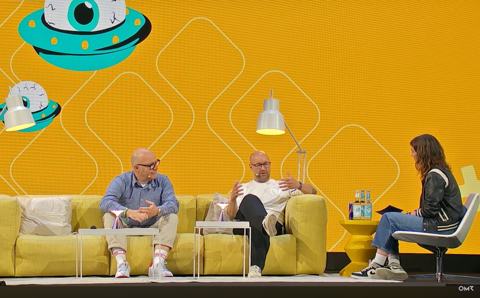 Gespräch auf der OMR-Bühne mit zwei Gästen auf einem gelben Sofa und einer Moderatorin